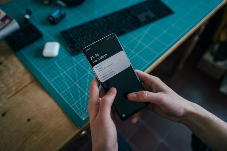 Hand holding phone notification settings screen